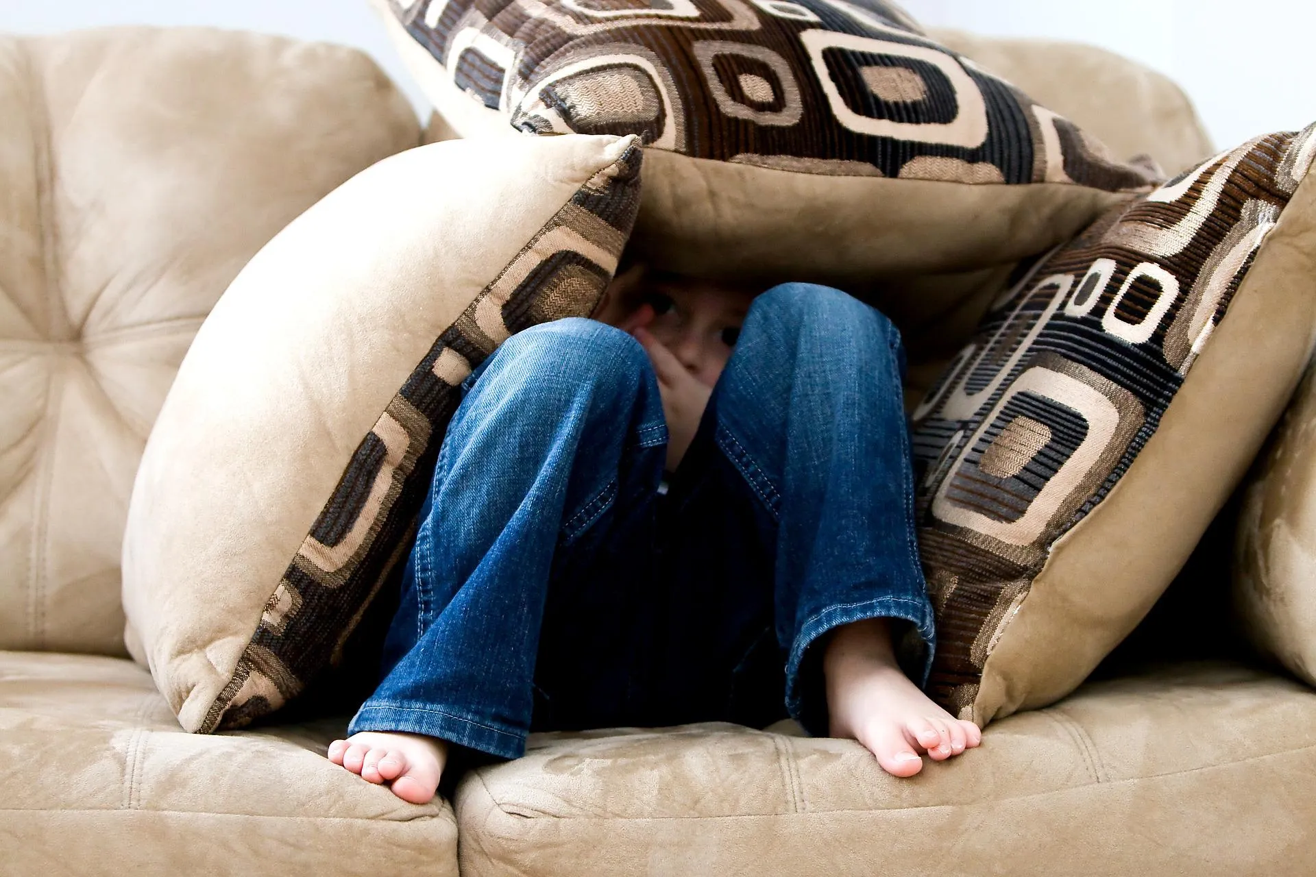 Quelle: pixabay.com Kind auf Sofa unter Kissen versteckt