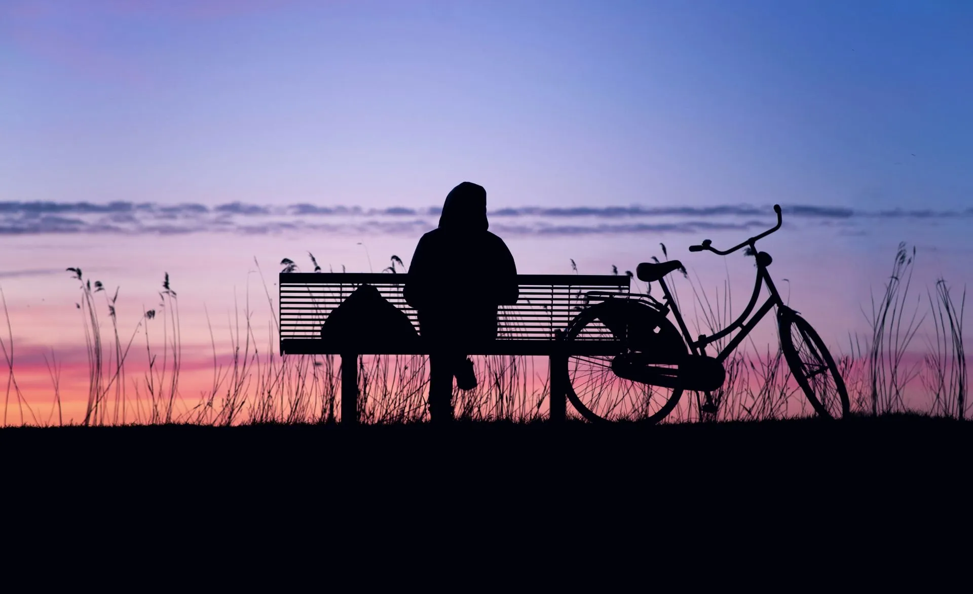 Quelle: RoonZ nl/Unsplash Silhouette einer Person, die beim Sonnenuntergang auf einer Bank sitzt