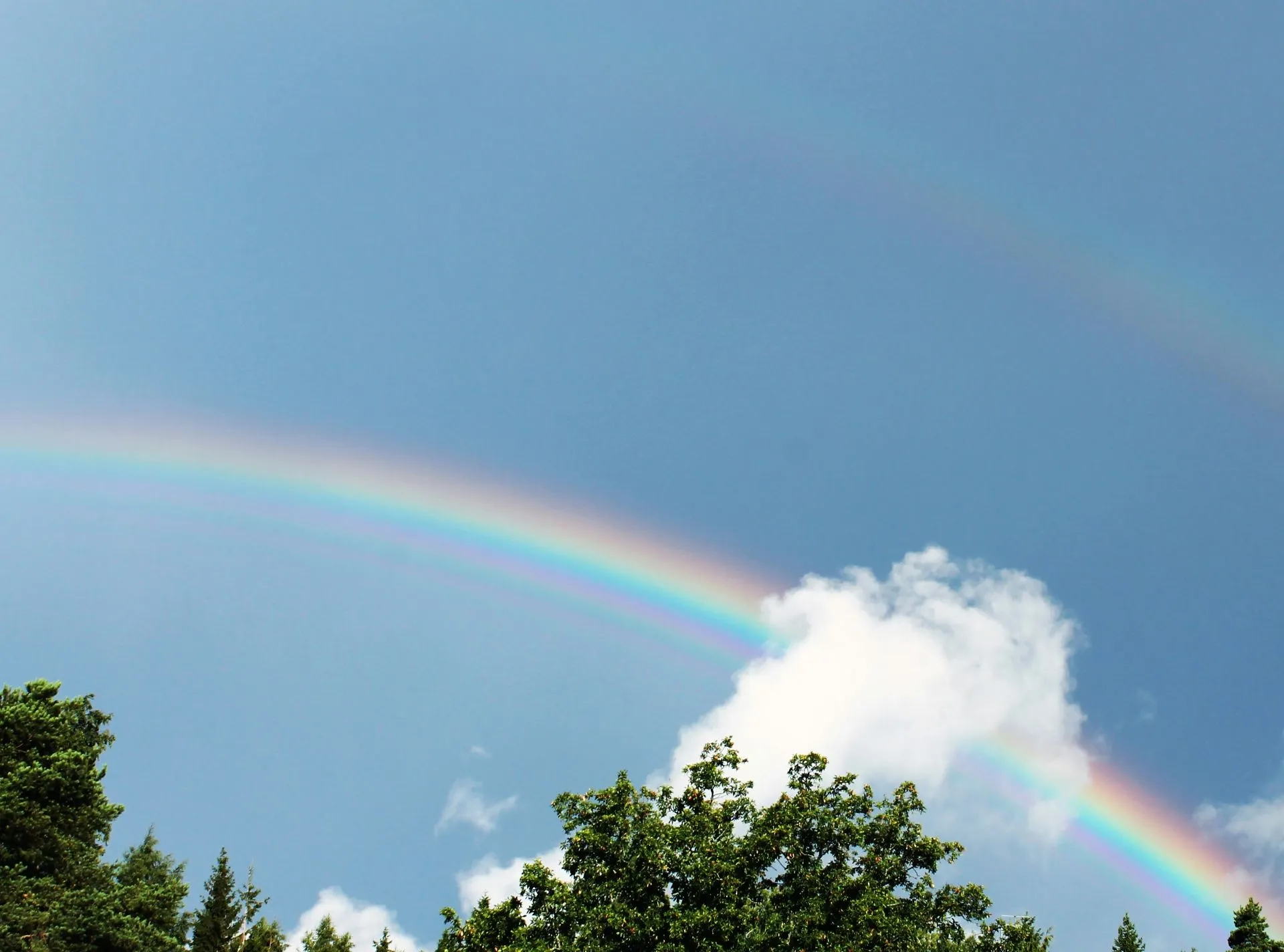 Regenbogen an blauem Himmel