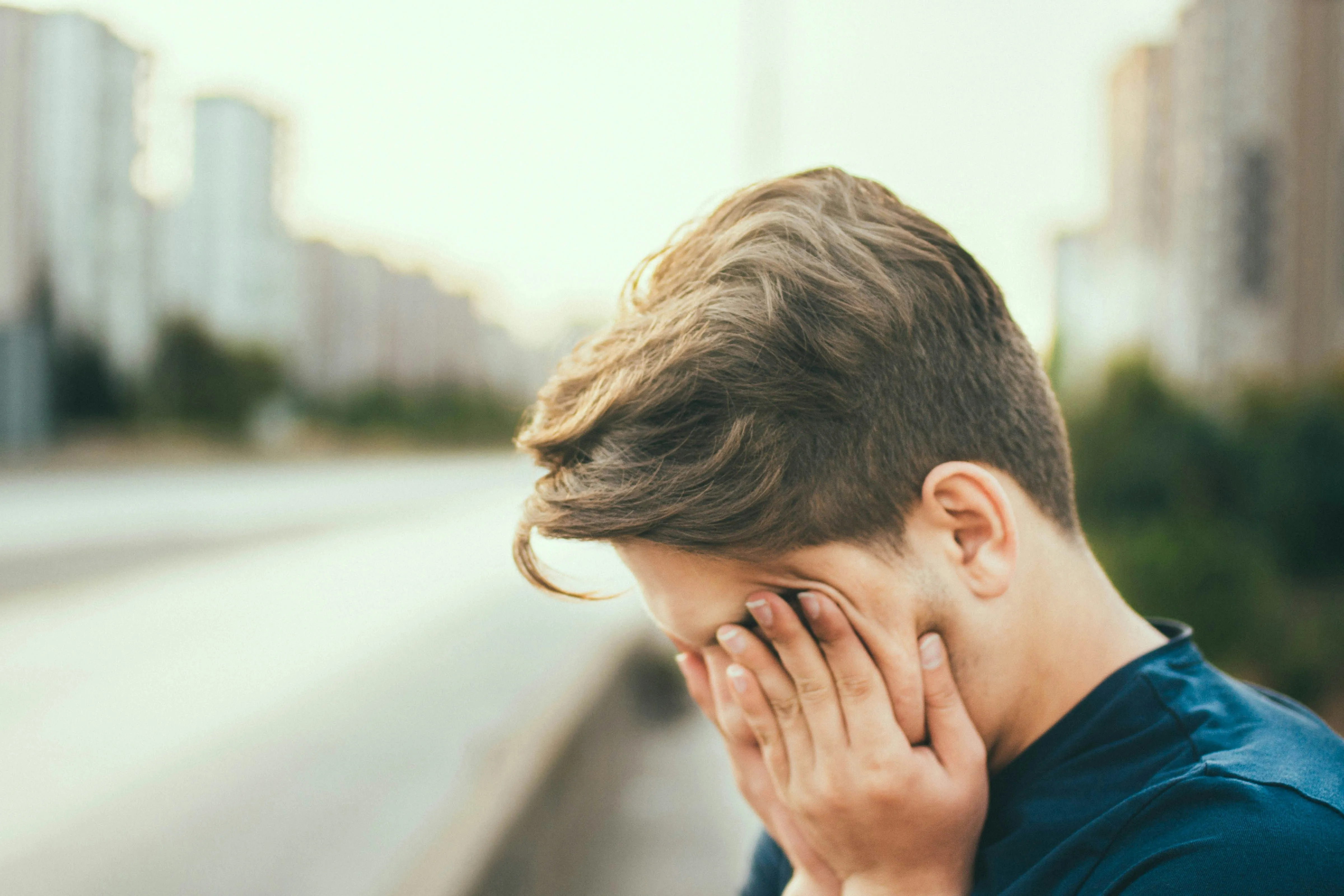 Person, die die Hände vor ihr Gesicht hält