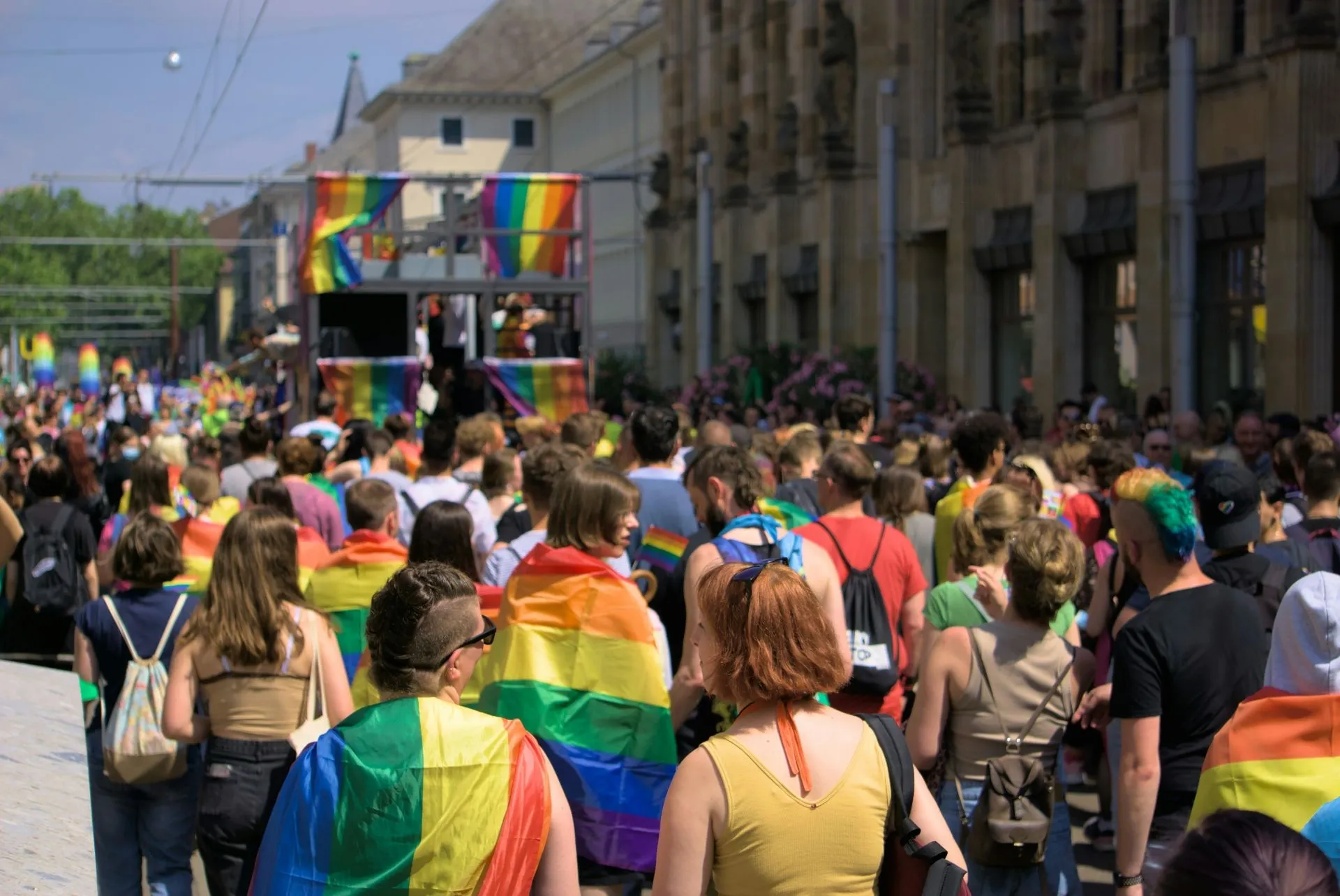 Menschen mir Regenbogenfahnen bei Parade zum Christopher Street Day