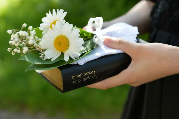 Konfirmandin mit neuem Gesangbuch