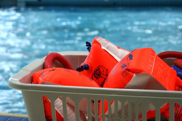 Korb mir orange-farbenen Schwimmflügeln