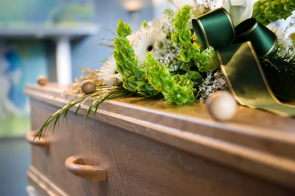 Holzsarg mit Blumenschmuck