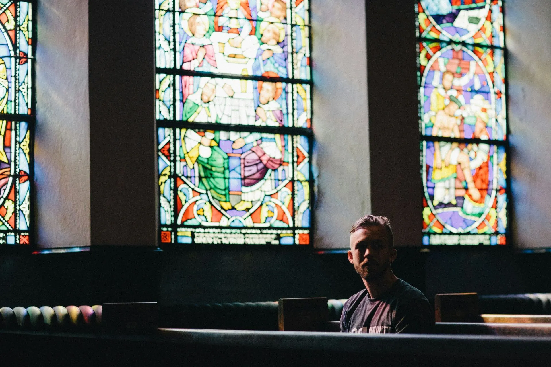 Mann sitzt in Kirchenbank