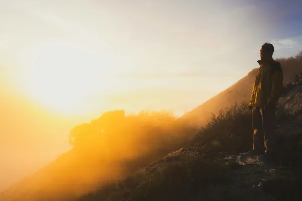 Mann blickt bei Sonnenuntergang auf Horizont