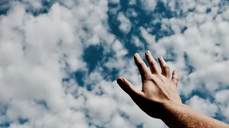 Hand, die nach den Wolken greift