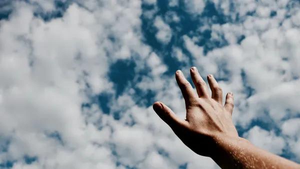Hand, die nach den Wolken greift