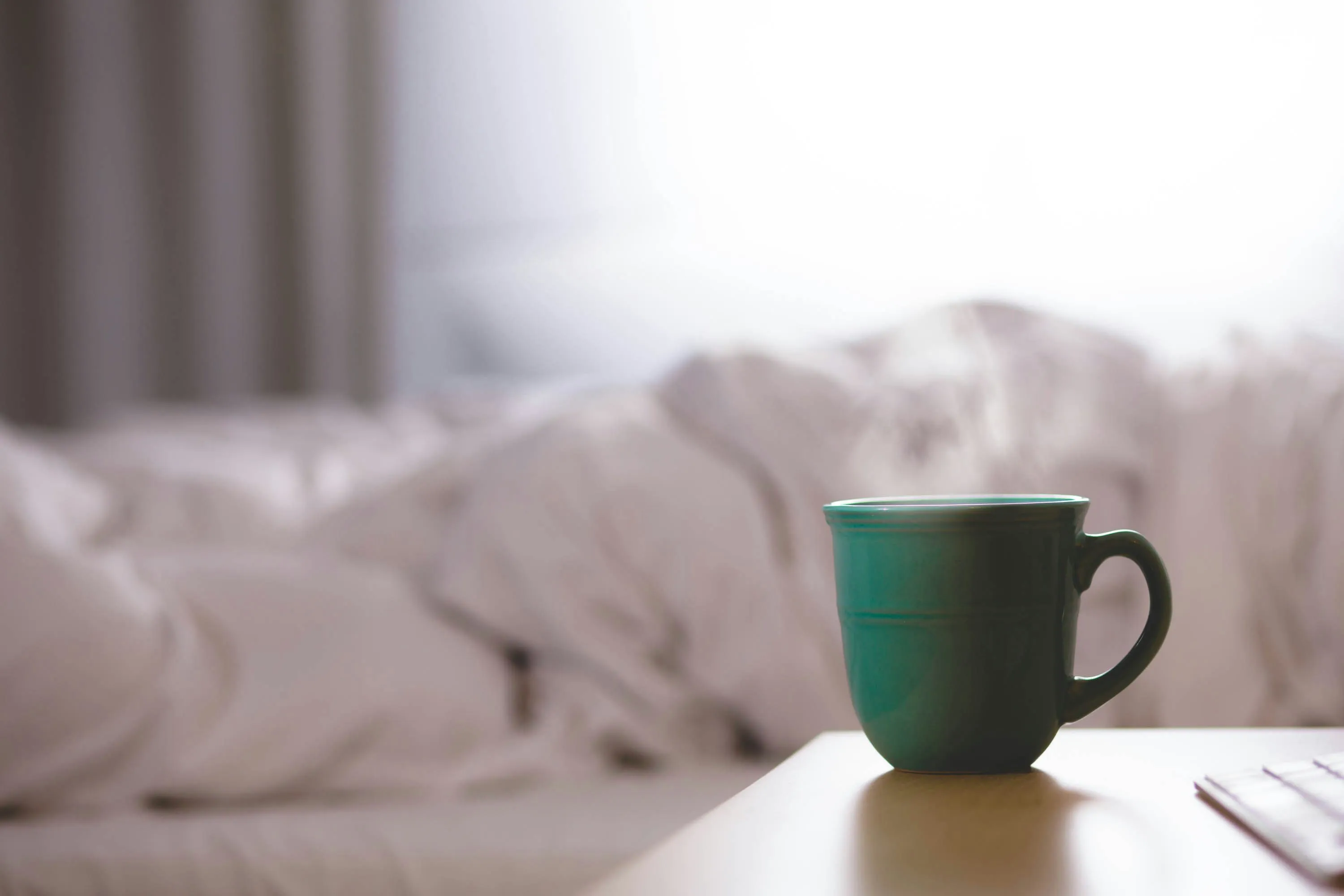 Kaffeetasse vor leerem Bett