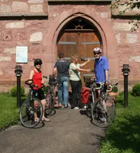 Gruppe von Radfahrern stehen vor einer Kirche