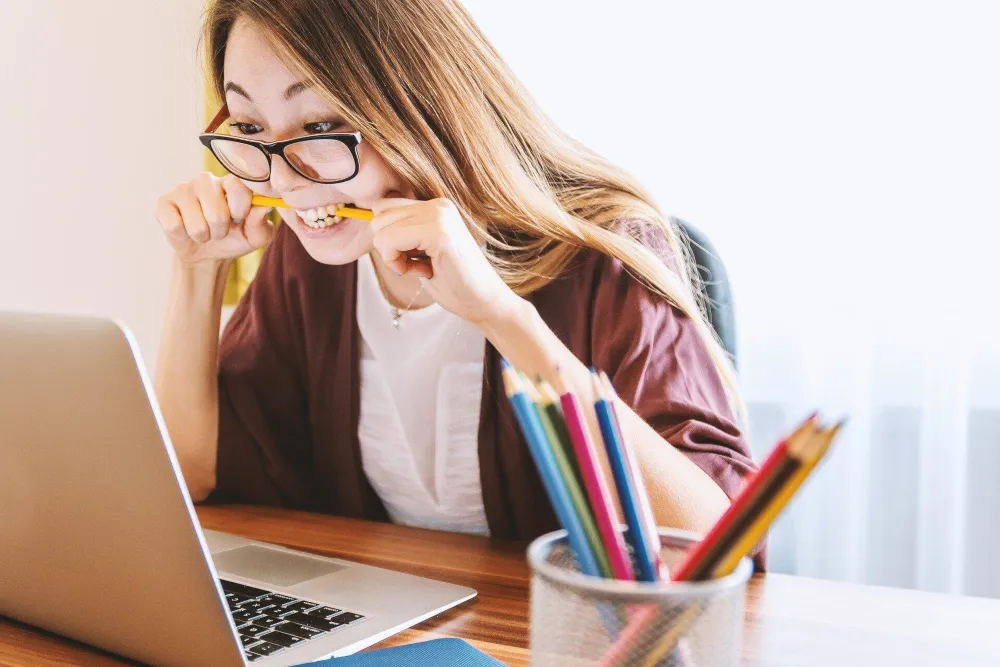 Quelle: Jan Vasek/Pixabay Frau vor einem Laptop, die auf einem Bleistift kaut