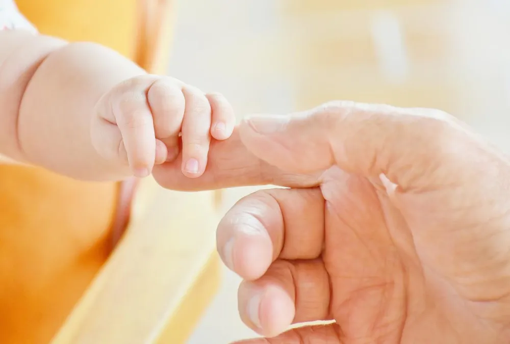 Quelle: RitaE/Pixabay Baby hält sich am Finger eines Erwachsenen fest.